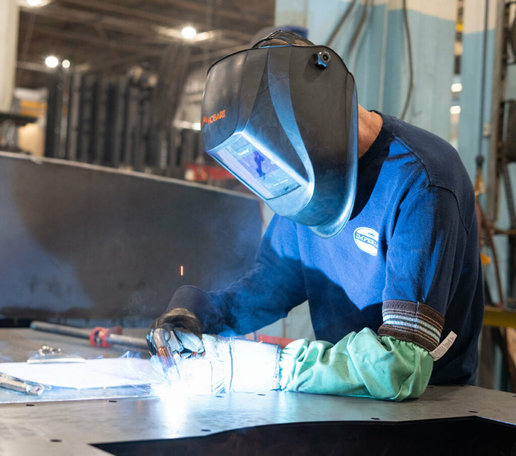 Welder at work enjoying clean air without having to wear a welding respirator due to the shop's dust collection system